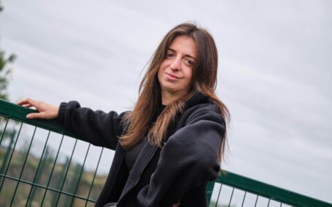 A pupil standing outside and smiling
